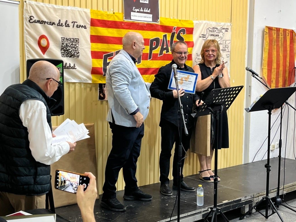 Ferran Navarro rep el reconeixement de mans del representant d'Esmorzars de la Terra Vicent Serra